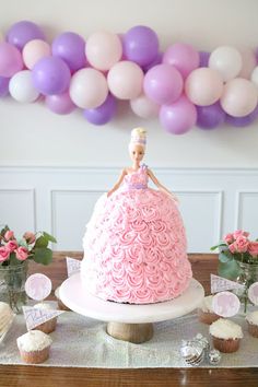 there is a cake that has been made to look like a princess on the table