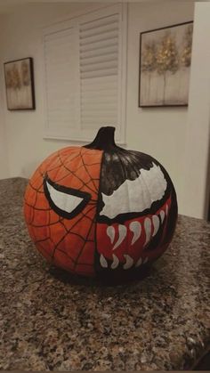 a pumpkin decorated with an evil face on top of a counter