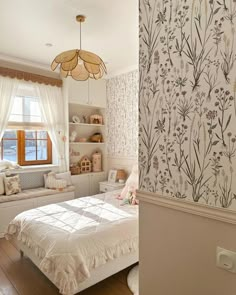 a bedroom with floral wallpaper and a bed in the corner next to a window