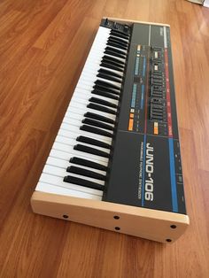 an electronic keyboard sitting on top of a wooden floor