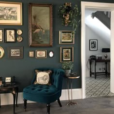 a living room with green walls and pictures on the wall, including a blue chair