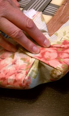 a person is sewing something on a piece of fabric that has been sewn together