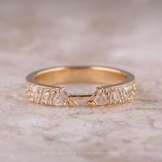 a yellow gold ring with three diamonds on the side and an arrow in the middle