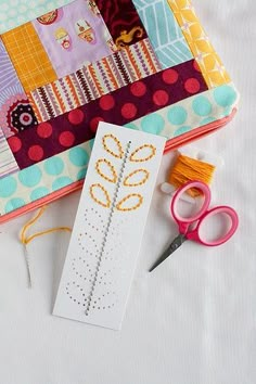 sewing supplies are laid out on a white table with scissors, thread, and fabric