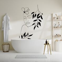 a bath room with a tub and a wall sticker that has a woman's face on it