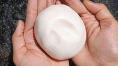 a person holding a white ball in their hands