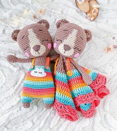 two crocheted teddy bears sitting on top of a bed next to each other