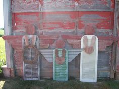 an old red barn with three wooden doors and two shutters on the front door