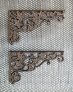 two decorative iron brackets on a wall