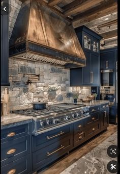 a kitchen with blue cabinets and a large stove top oven in the middle of it