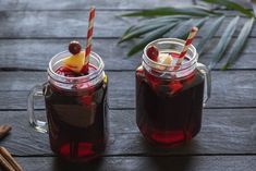 two mugs filled with hot drinks on top of a wooden table next to cinnamon sticks