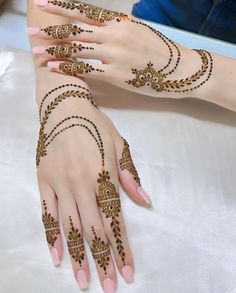 two hands with hendi designs on them