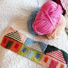 three balls of yarn sitting on top of a bed next to each other