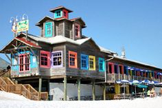 the building has colorful windows and balconies on it's roof, along with stairs leading up to the second floor