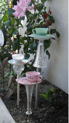 three tiered dishes are stacked on top of each other in front of a flower garden