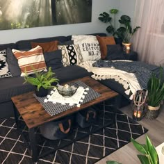 a living room filled with lots of furniture and plants on top of a wooden table