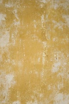 an old yellow wall with white paint on it