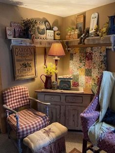 a living room with two chairs and a table in front of the wall covered in quilts