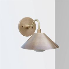 a white wall light with a metal shade on it's arm and the bulb turned off