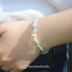 a close up of a person's arm wearing a bracelet with beads on it