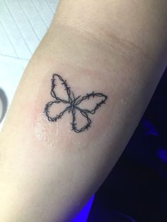 a small tattoo on the arm of a woman's left arm with a butterfly