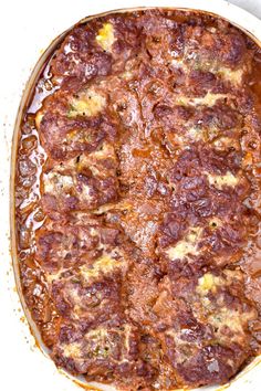 a casserole dish with meat and cheese in it sitting on a table top