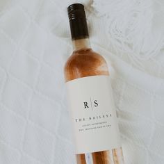 a bottle of wine sitting on top of a white blanket