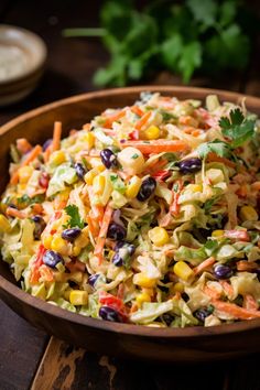 a wooden bowl filled with coleslaw salad and garnished with cilantro