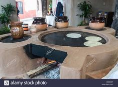 an outdoor fire pit with pots and pans on it