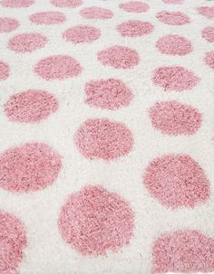 a pink and white rug with circles on the top is shown in close up view