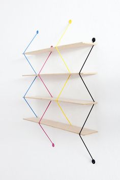 three shelves with different colored sticks sticking out of the top and one shelf on each side