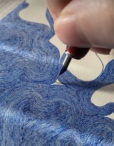 a person using a pen to draw on fabric