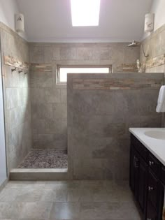 a bathroom with a sink, toilet and shower in it's stall area next to a window