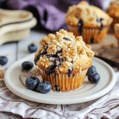 blueberry muffins with crumbs on a plate