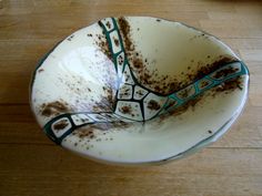 a brown and white bowl on top of a wooden table