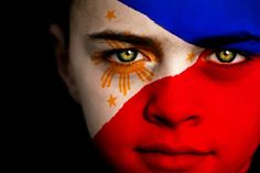 a man with his face painted in the colors of the philippines flag and gold stars