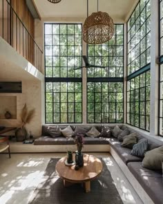 a living room filled with lots of furniture and large windows above it's walls