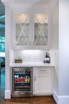 a kitchen with white cabinets and an open beverage cooler in the middle of the room