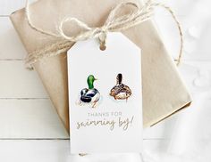 two ducks sitting on top of a brown package with the tag saying thanks for swimming by