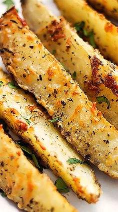 grilled potato wedges on a white plate garnished with parmesan