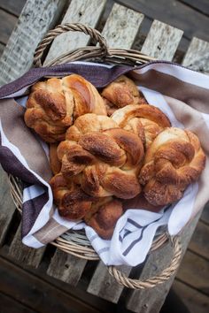 a basket filled with croissants sitting on top of a wooden table