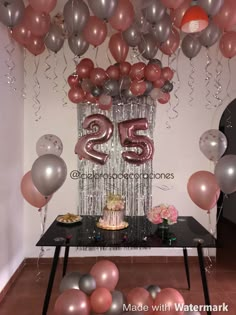 a table topped with balloons and a cake