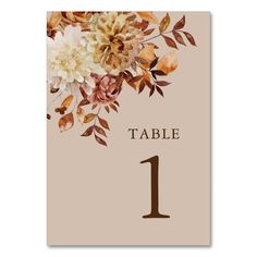 a table number with flowers on it and the number one in brown, beige and white