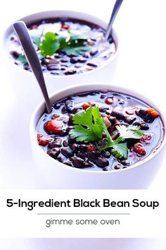 two bowls filled with black bean soup and garnished with cilantro