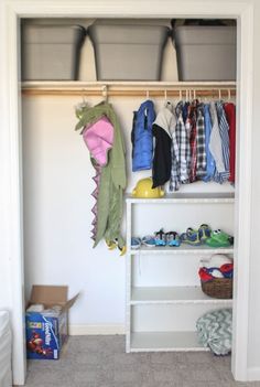 an organized closet with clothes hanging on shelves and shoes in bins next to it