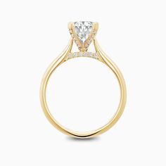 a yellow gold engagement ring with a princess cut diamond in the center and side stones