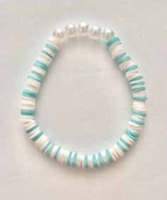 Teal and white clay bead stretch bracelet with pearls - 6.5" All jewelry is made with care by my 11 year old granddaughter. She's quite the entrepreneur and loves earning her own spending money.  A great gift for a special girl! Clay Bead Necklaces Ideas, Teal Clay Bead Bracelet, Clay Bead Brackets Ideas, Clay Bead Bracket Idea, Clay Bead Bracelet Inspo Aesthetic, Pearl Clay Bead Bracelet Ideas, Trendy Clay Bead Bracelets, Adjustable Hypoallergenic White Pearl Bracelet, Playful White Heishi Beads Stretch Bracelet