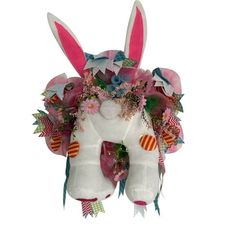 a white stuffed animal with flowers on it's head