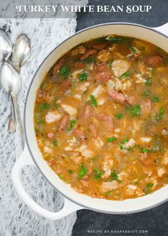 turkey white bean soup in a large pot with spoons on the side and napkin next to it