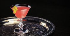 a pink drink sitting on top of a metal tray